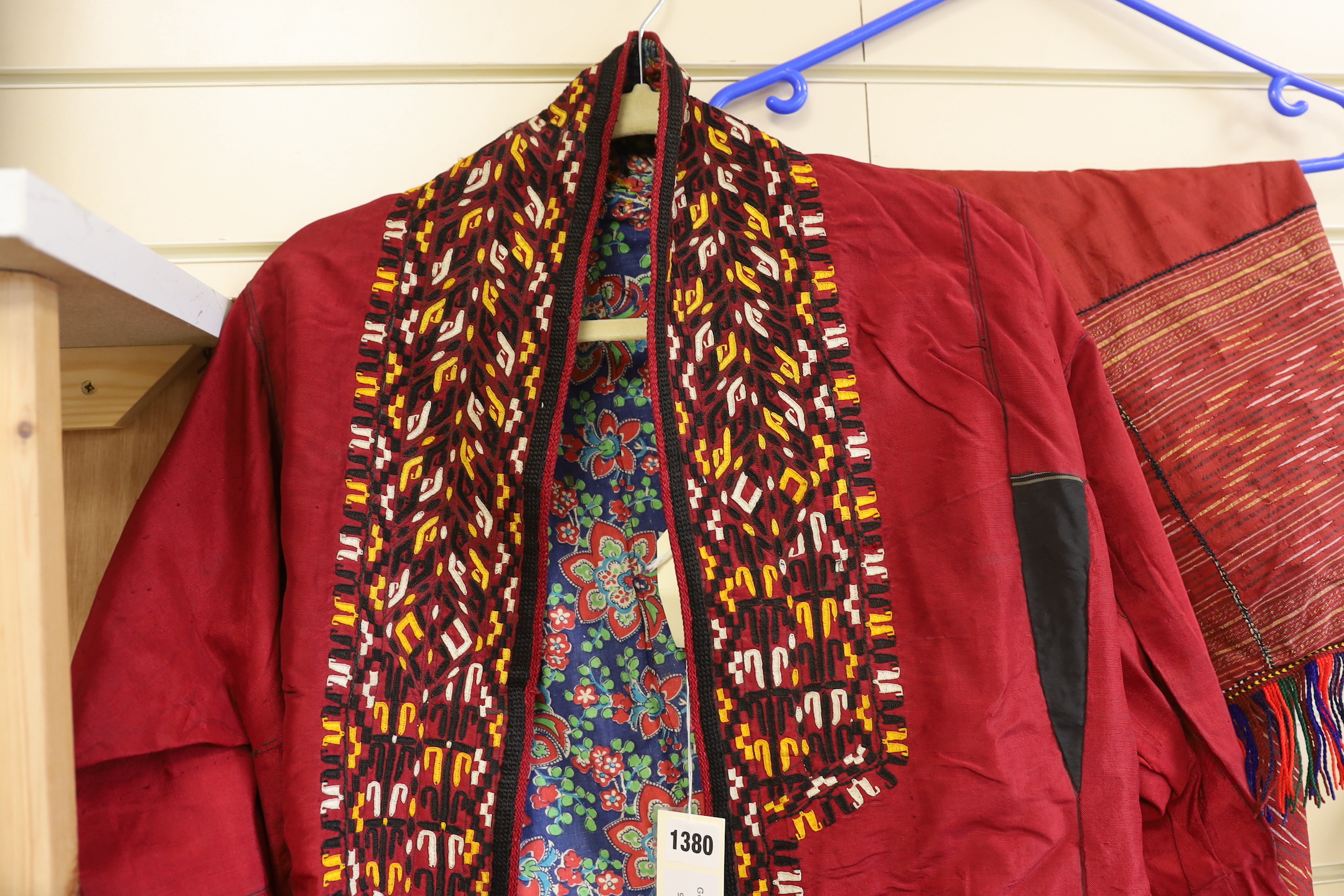 A Tekke Turkoman woman's red ground robe (khalat), the collar embroidered with red, gold and white devices, together with a red triangular shawl, longest side (2)